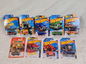 lot 26 image: Hot Wheels and Matchbox Die-Cast Vehicles Collection featuring models such as the Hot Wheels Quick Bite, Hiway Hauler 2, Ultimate T-Rex Transporter, and the Matchbox MBX Self-Driving Bus.