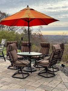lot 24DD image: 7-Piece Outdoor Patio Set with Glass Table, 6 Cushioned Chairs, and Orange Umbrella