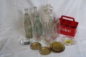 lot 136 image: Vintage Coca-Cola Bottles Set with Tropicana Orange Juice Bottles, Glass Jug, Coke Carrier, and Ashtrays