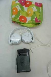 lot 123 image: Sony Folding Plug-In Headphones, Radio Shack Portable Handheld Radio, Clinique Makeup Bag