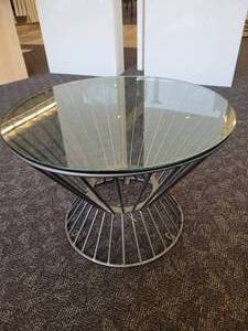 lot 100 image: A Glass Top Hour Glass Side Table.