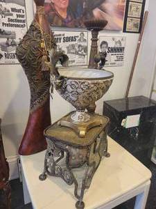 lot 150 image: A group lot of items. Rams Head Urn, A Floor Candlestick, Decorative Metal Stand & Abstract Wood Figure.