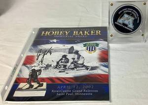 lot 161 image: Jordan Leopold Autographed Hockey Puck and Autographed Hobey Baker Award Program April 12, 2002  - LOT 2