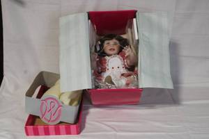 lot 36 image: Porcelain Baby Doll in Original Box with Red Checkered Dress