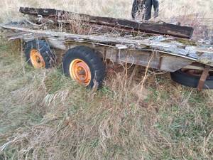 lot 27 image: Used Flatbed Wagon Frame with Dual Axles and Weathered Deck or Scrap