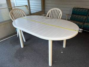 lot 137 image: Outdoor Patio Set with Oval Table and 4 White Plastic Armchairs
