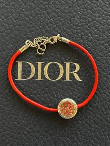 lot 48 image: Christian Dior Red Cord Bracelet with Gold-Tone CD Medallion Pre-Owned Retail $350