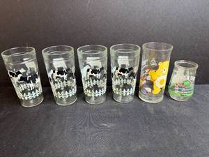lot 137 image: Set of Vintage Drinking Glasses Including Cow Farm, Care Bears, and Welchs Planet Designs