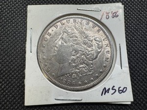 lot 12 image: 1886 Morgan Silver Dollar Marked MS 60 when purchased