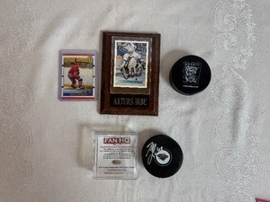 lot 116 image: Hockey  Mario Lucia Autographed Puck, 1990 Eric Lindros Future Super Star Trading Card, Mounted Arturs Irbe Trading Card and Soft Puck