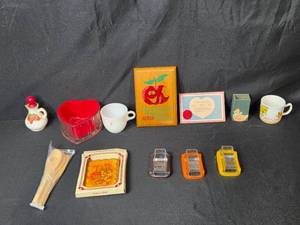 lot 65 image: Vintage Kitchen and Decor Collection with Mini Graters, Avon Bath Foam, Mugs, and Plaques