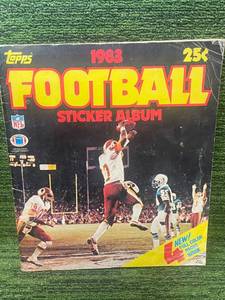 lot 173 image: 1983 Topps Football Sticker Album Half Full of stickers