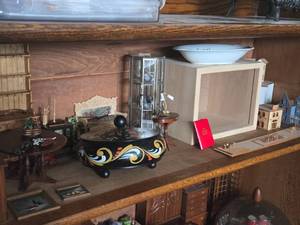 lot 914 image: Lot of (1 Shelf) Miniature Doll House Accessories - Wood Display Box, Hexagon Display Cabinet, Dining Furniture (Buffet, Wash Sink, Dining Table and Chair), Violin, Side Tables with Dcor, Cat Statue, Large Ceramic Bowl with Lid, Scale Houses and more