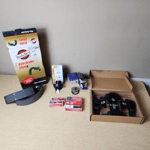 lot 32 image: Automotive Parts Collection including BrakeBest Brake Shoes, Motorcraft Spark Plugs (SP-486), and NAPA Thermostat, Halogen headlamp (type HB1 9004).