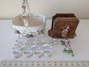 lot 74 image: Porcelain Rose Table Decor Collection with Basket, Napkin Rings, and Wooden Stand