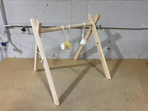 lot 227 image: Wooden Baby Play Gym - Natural Finish Pinewood Baby Activity Gym with 3 Sensory Hanging Toys -  Safe and Durable for Infant Motor and Visual Development - Natural Wood (Missing Hardware)