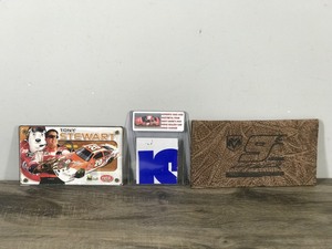 lot 209 image: Lot of NASCAR Collectibles - 2001 Authentic Images Tony Stewart #20 Collectible Card, Authentic Race used sheet metal from Kasey Kahnes 2005 Dodge dealers UAW Dodge Charger and Kasey Kahnes #9 Leather Wallet