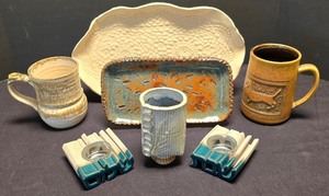 lot 246K image: LR - Decorative Tableware Lot Ivory Oval Tray BlueRust Tray Blue Vase Brown & Tan Mugs Candleholders