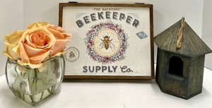 lot 402 image: Beekeeper Supply Co. Sign & Birdhouse & Peach Roses in Glass Vase