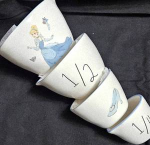 lot 530 image: Sad Iron (flat clothing iron) from the 19th Century, Disney Princess set of 4 measuring cups By Rae Dunn, Porcelain Chrysanthemum shape pair of salt and pepper shakers