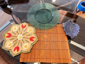 lot 34 image: Kitchen Decor and Tableware Lot with Glass Plate, Felt Mat, Bamboo Placemat, and Leaf Dish