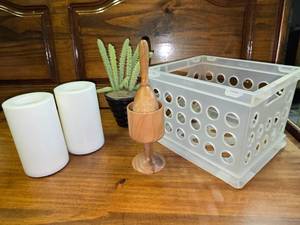lot 94 image: Small plastic bin, 2 battery operated candles, fake succulent, wood bowl with crusher