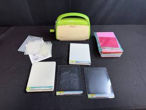 lot 75 image: Cuttlebug Die Cutting and Embossing Machine with Plates, Embossing Folders, and Cardstock Lot