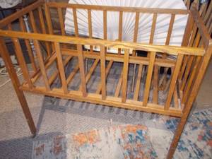 lot 23 image: This appears to be a vintage wooden baby crib or bassinet,