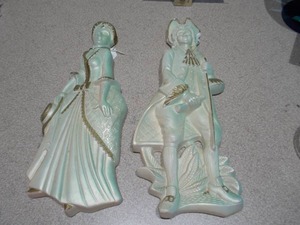 lot 115 image: These are vintage ceramic figurines, likely French Provincial or Colonial Regency style, featuring a gentleman and a lady