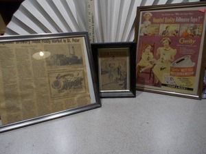 lot 130 image: The image displays three framed vintage advertisements and historical newspaper clippings.