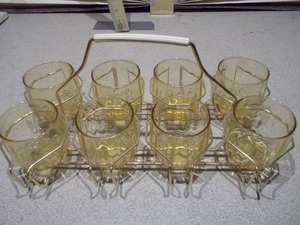lot 144 image: This is a set of eight Libbey Tempo Amber Flat Tumblers in a metal caddy.