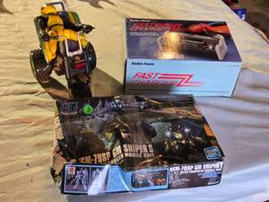 lot 294 image: Radio Shack Fast Charger and a RGM-79SP GM Sniper II model kit, and a toy ATV with rider.