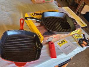 lot 310 image: Lodge Cast Iron Grill Pan Set with Red Silicone Handle Holder and Other Cast Iron Grill Pan