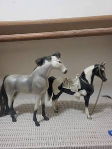 lot 103 image: Pair of Saddled Horse Figurines - Grey and BlackWhite Pinto with Ornate Saddles