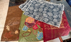 lot 257 image: Brown bag near Hutch - Embroidered Floral Fabric Table Runners and 3 Easter Placemats- Brown, Green Olive, Navy Paisley & Red Damask