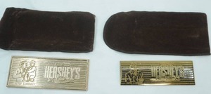 lot 113 image: (2ct) Hersheys 100th Anniversary (1894-1994) gold-finish Candy Bar Paperweights with Brown Velour Storage Pouches