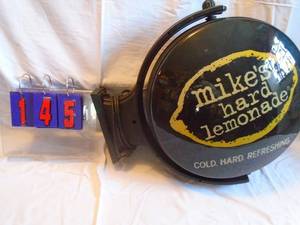lot 145 image: Mikes Hard Lemonade rotating wall mount sign. Dent on one face. Lights & spins. As shown.