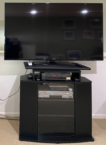 lot 121 image: Samsung TV on Black Entertainment Stand - JVC DVDVHS Players & Remotes Included