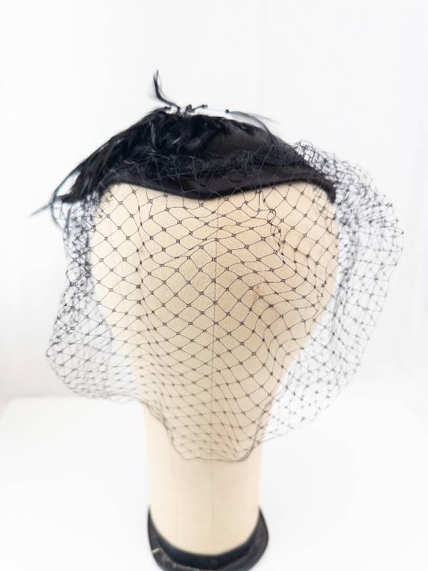 lot 126 image: Black Satin Pillbox Hat with Net Veil and Feather Accent