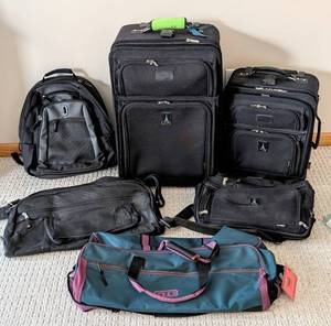 lot 284 image: ML - Travelpro 5-Piece Luggage Set - Black Upright Suitcases, Backpack & Teal Duffel