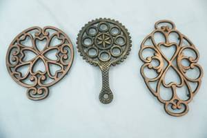 lot 171 image: 2 Pampered Chef Iron Trivets and one other cast iron trivet