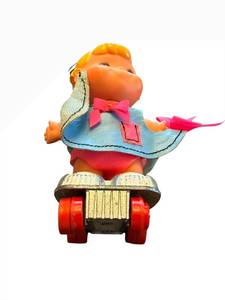 lot 32 image: Small Shots Vintage Plastic Toy Figure on Roller Skateboard - Blue Cape & Pink Bow