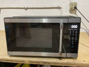 lot 205 image: Hamilton Beach 1.1 cu ft Countertop Microwave Oven, Black and Stainless Steel Model hb8436193153-01 UPC 840296508909 (Used, Missing Plate)