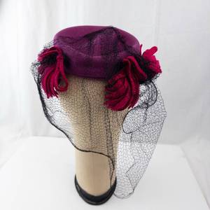 lot 330 image: Pillbox Hat Magenta with Black Net Veil and Red Floral Accent