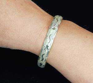 lot 402 image: Sterling silver hinged bangle bracelet with a starburst and wave etched design.