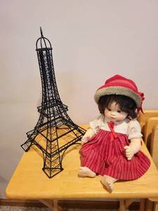 lot 279 image: Suzanne Gibson 1980 Porcelain Doll with Red Dress and Eiffel Tower Metal Sculpture