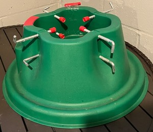 lot 89 image: Christmas Tree Stand, Green Plastic With Center Hole And Eight Red-Capped Bolts