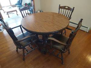 lot 25 image: Round Wooden Pedestal Table With (2) Leaves and (4) Heavy Wood and Leather Chairs
