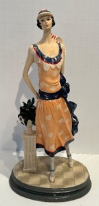 lot 123 image: Porcelain Figurine - Tall Art Deco Woman in Orange Dress &amp Blue Sash with Striped Hat