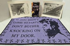 lot 155 image: Prince Purple Rain Memorabilia - Doormat 16x24, Purple Rain VHS, 2 Graffiti Bridge 8x10 Photos